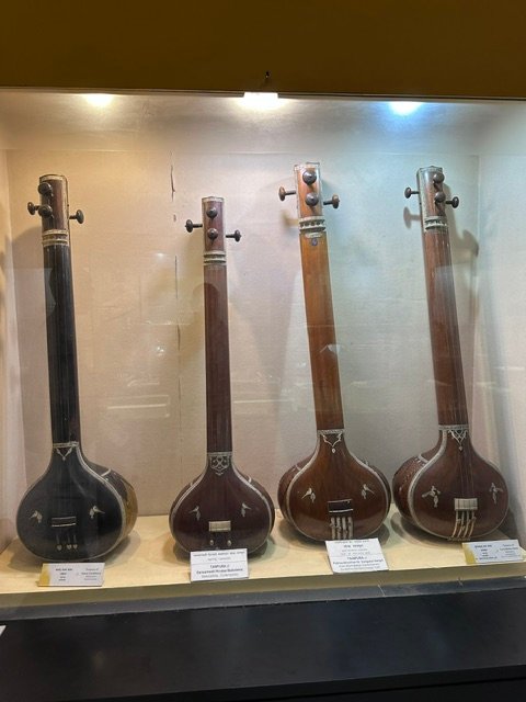 A display of four tanpuras, long-necked classical Indian string instruments, in the Kelkar Museum